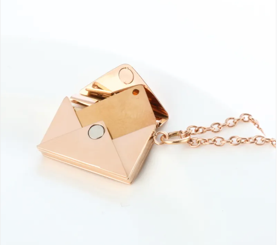 Rose gold envelope locket necklace open, showing the hinged flap