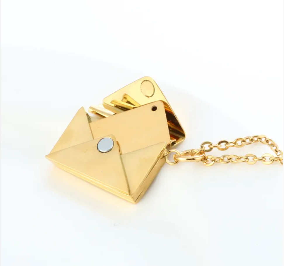 Gold envelope locket necklace open, showing the magnetic closure
